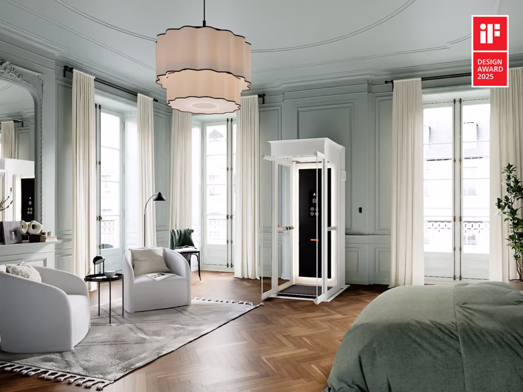 White glass Ascenda home elevator in a traditional room with tall windows and pale green walls.
